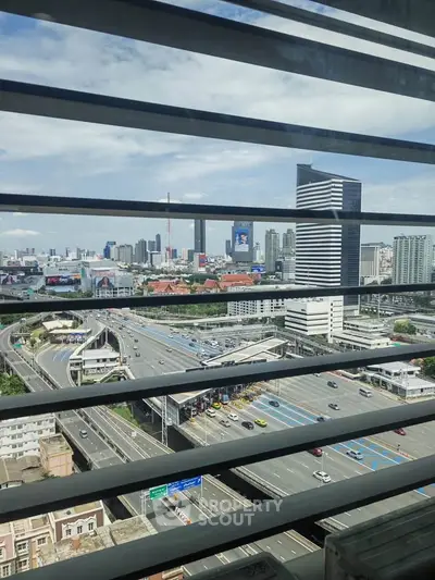 Stunning cityscape view from high-rise building with modern architecture and bustling highway.