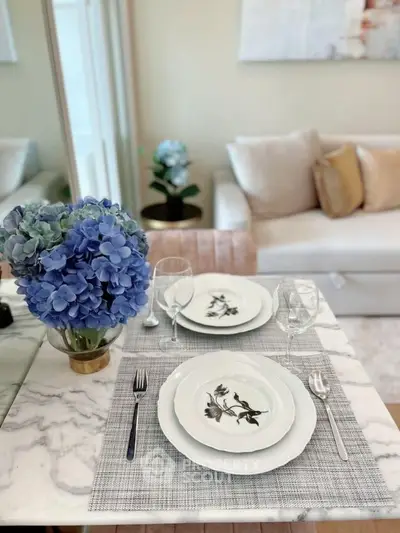 Elegant dining setup with floral centerpiece in modern living room.