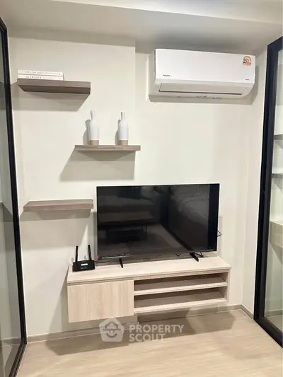 Modern living room with sleek TV setup and air conditioning unit, perfect for comfortable living.