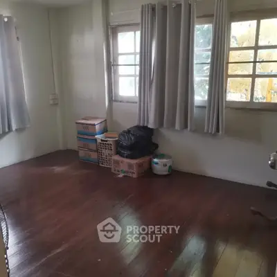 Spacious room with wooden flooring and natural light, ideal for storage or creative use.