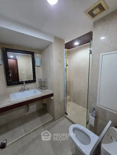 Modern bathroom with elegant marble tiles and glass shower enclosure