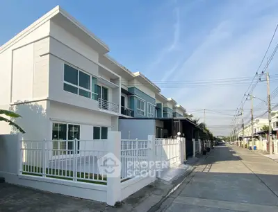 Modern townhouse exterior with clean lines and spacious driveway in a suburban neighborhood.