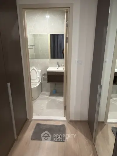 Modern bathroom with sleek design and neutral tones, featuring a stylish sink and toilet.