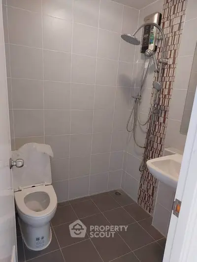 Modern bathroom with sleek shower and toilet in minimalist design.