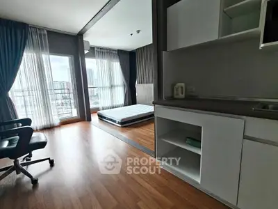 Spacious modern apartment with large windows and wooden flooring, featuring a cozy bedroom and study area.