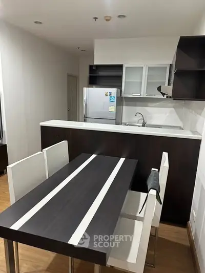 Modern kitchen with sleek dining area and stylish cabinetry in a contemporary apartment.