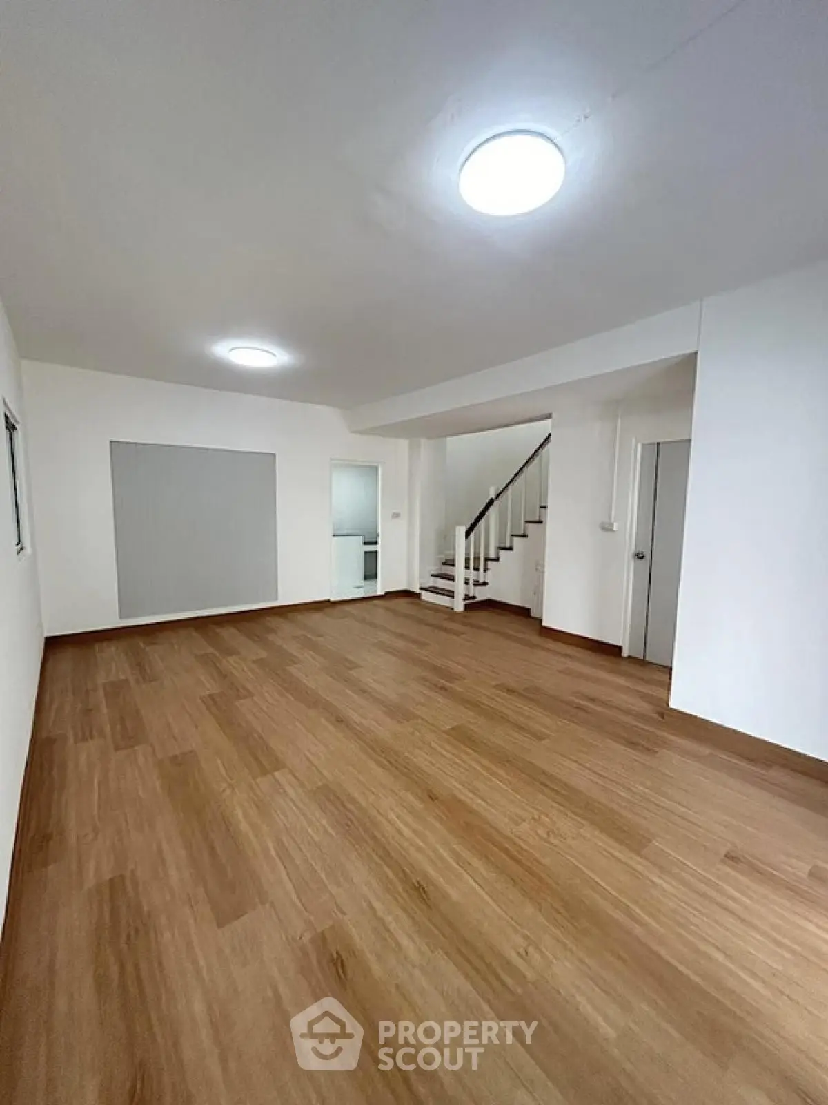 Spacious modern living room with wooden flooring and staircase