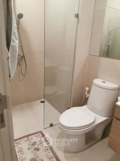 Modern bathroom with glass shower and sleek fixtures in a contemporary apartment.