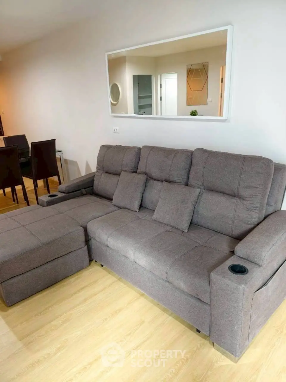 Spacious living room with modern gray sectional sofa and elegant decor.