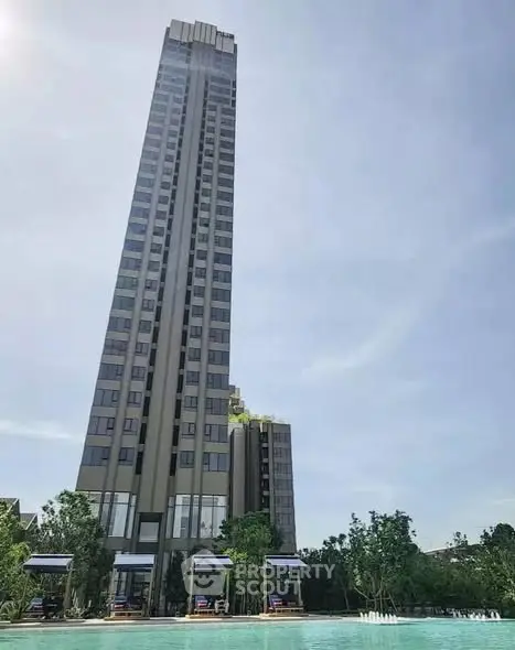 Stunning high-rise building with lush greenery and poolside view, perfect for luxury urban living.