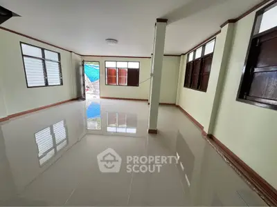 Spacious living room with glossy tiled floors and large windows for natural light.