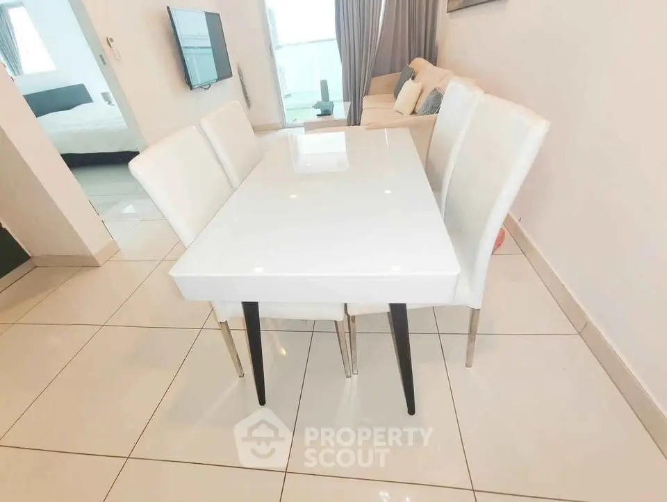 Modern dining area with sleek white table and chairs in a stylish apartment.