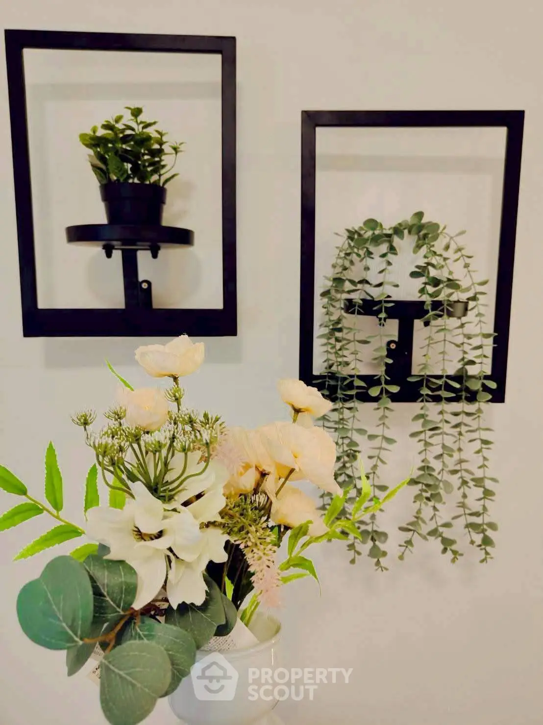 Stylish wall-mounted plant holders with lush greenery and elegant floral arrangement, perfect for modern interior decor.