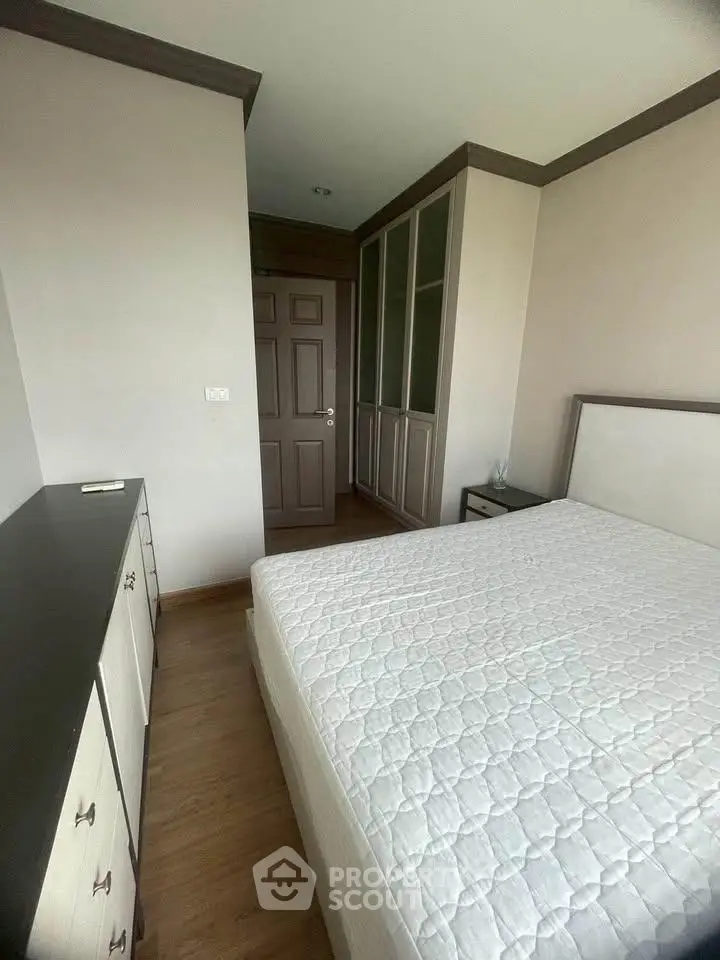 Spacious bedroom with modern furnishings and ample storage in a stylish apartment.