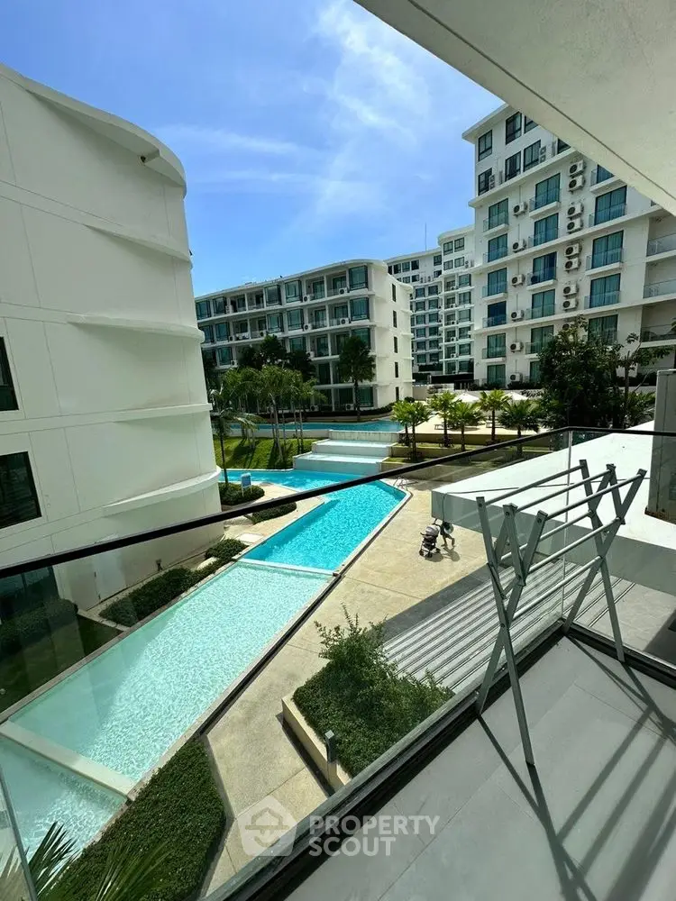 Luxurious condo balcony with stunning pool view and modern architecture