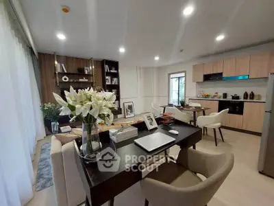 Modern open-layout living room and kitchen with stylish decor and ample natural light.