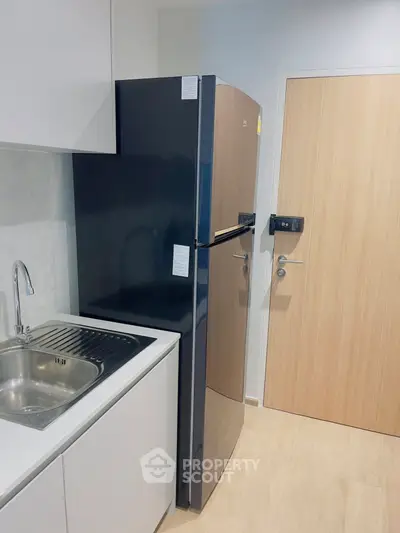 Modern kitchen with sleek fridge and compact sink area