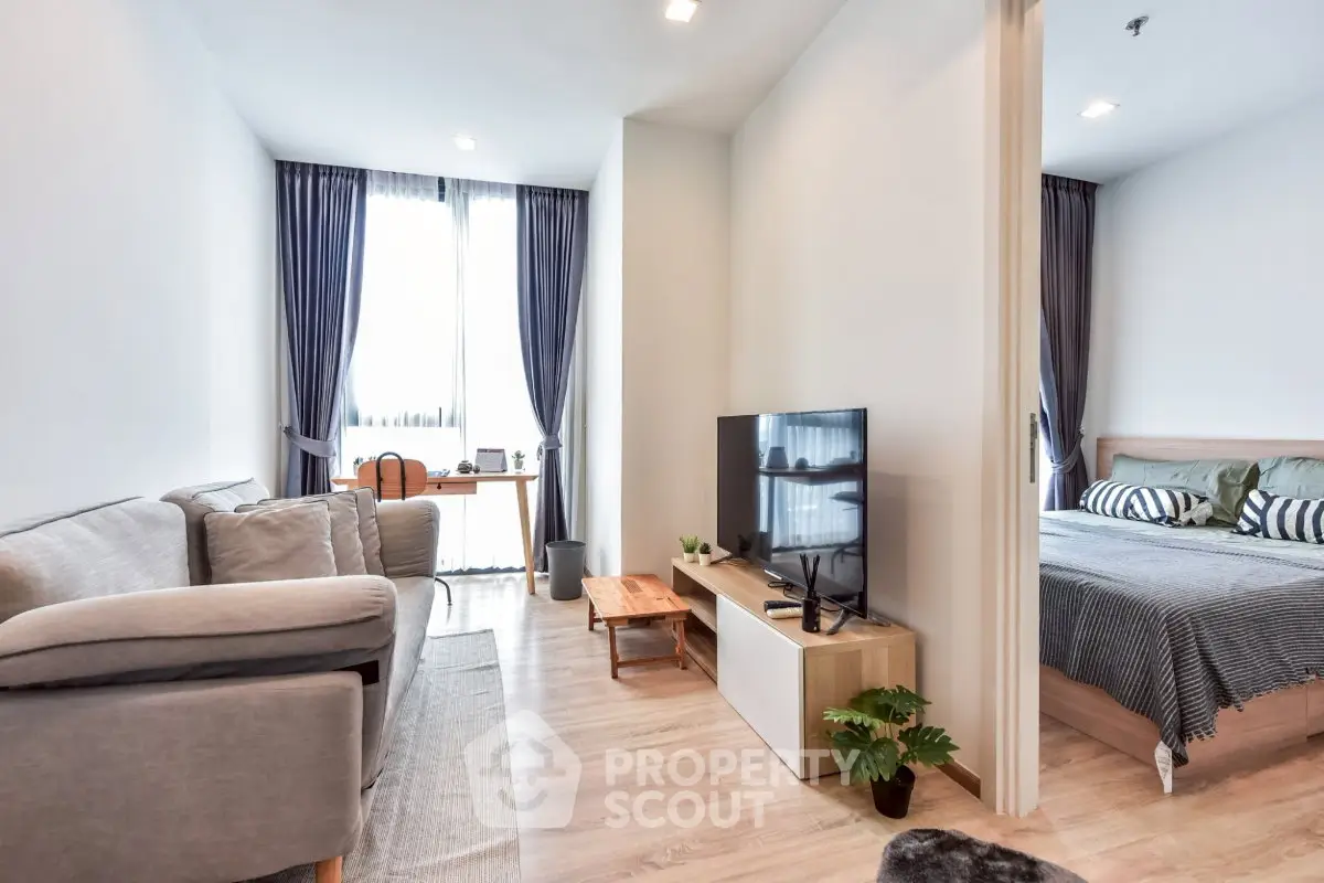 Modern open-plan living room with cozy bedroom, stylish decor, and natural light.
