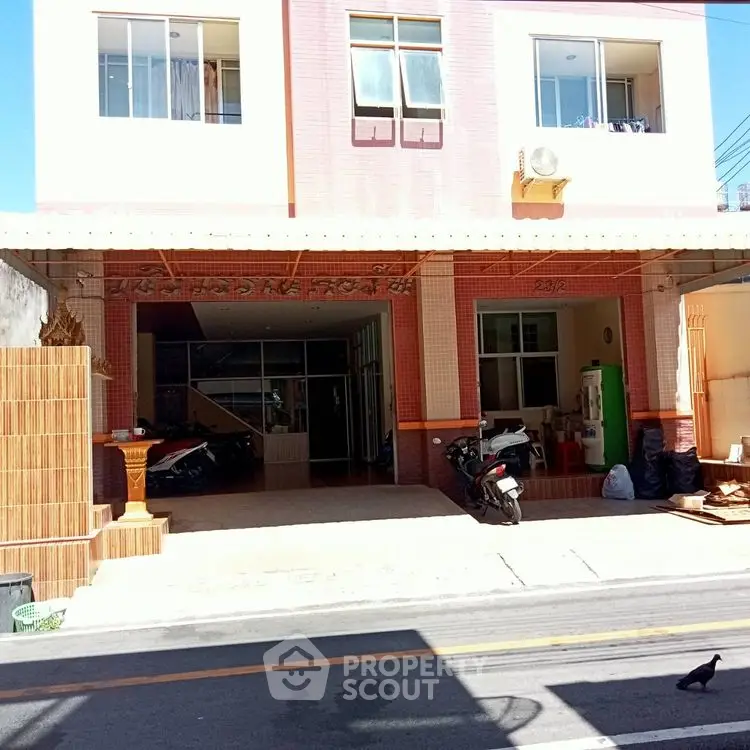 Charming two-story building with street view and parking area, ideal for urban living.
