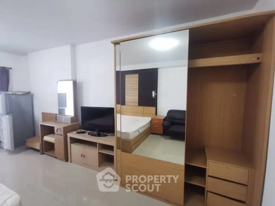 Spacious studio apartment with modern furnishings and ample storage space.