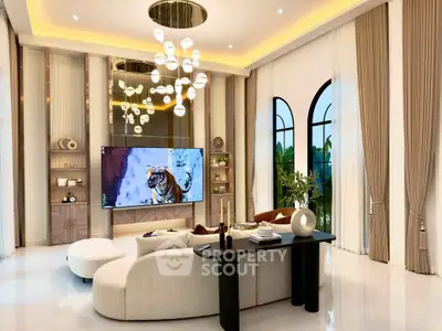 Luxurious living room with high ceilings, elegant lighting, and modern decor