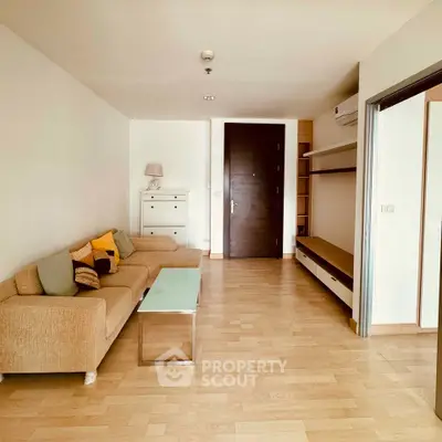 Spacious living room with modern furniture and wooden flooring in a stylish apartment.