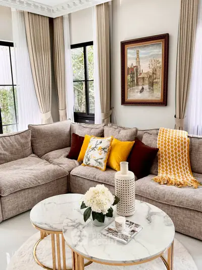 Elegant living room with cozy sectional sofa, stylish decor, and natural light through large windows.