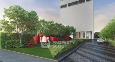 Modern building entrance with lush landscaping and sleek driveway