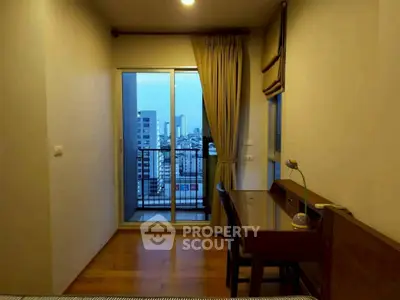 Cozy bedroom with city view balcony and study desk, perfect for urban living.
