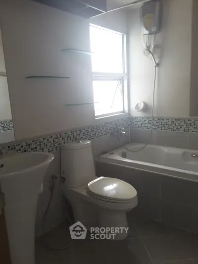 Modern bathroom with bathtub, shower, and sleek fixtures in a well-lit space.