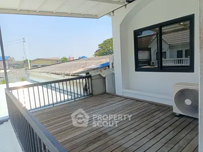 Spacious balcony with wooden flooring and scenic neighborhood view, perfect for relaxation and outdoor activities.
