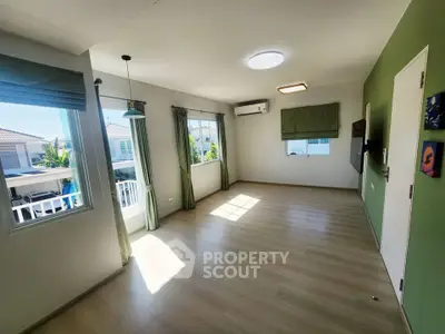 Spacious and bright living room with large windows and modern decor, perfect for family gatherings.