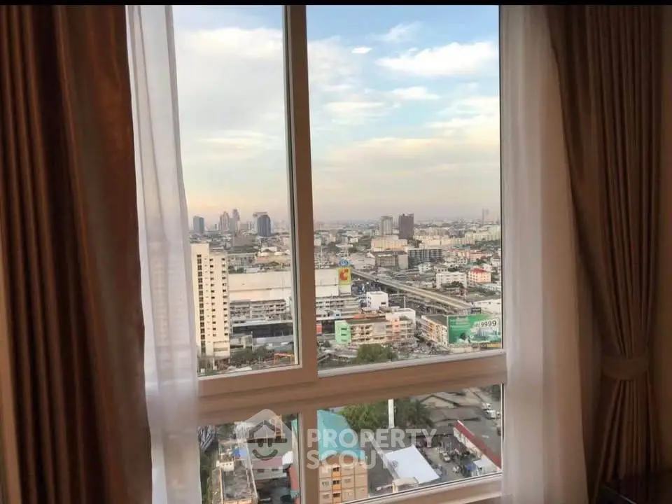 Stunning cityscape view from high-rise apartment window with elegant curtains.