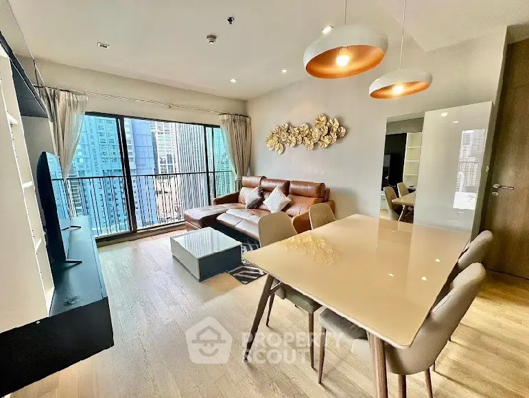 Modern living room with city view, stylish decor, and open dining area in high-rise apartment.