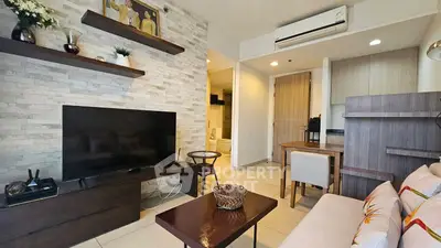 Modern living room with stylish decor and large TV in a cozy apartment.