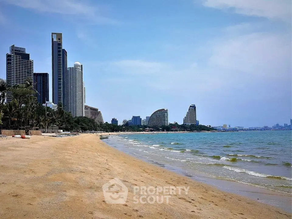 Stunning beachfront view with modern high-rise buildings and clear blue sky.