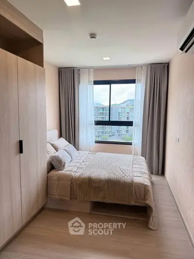 Modern bedroom with large window and stylish decor in a high-rise apartment.