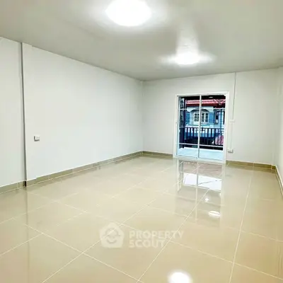Spacious empty room with glossy tiled floor and balcony view