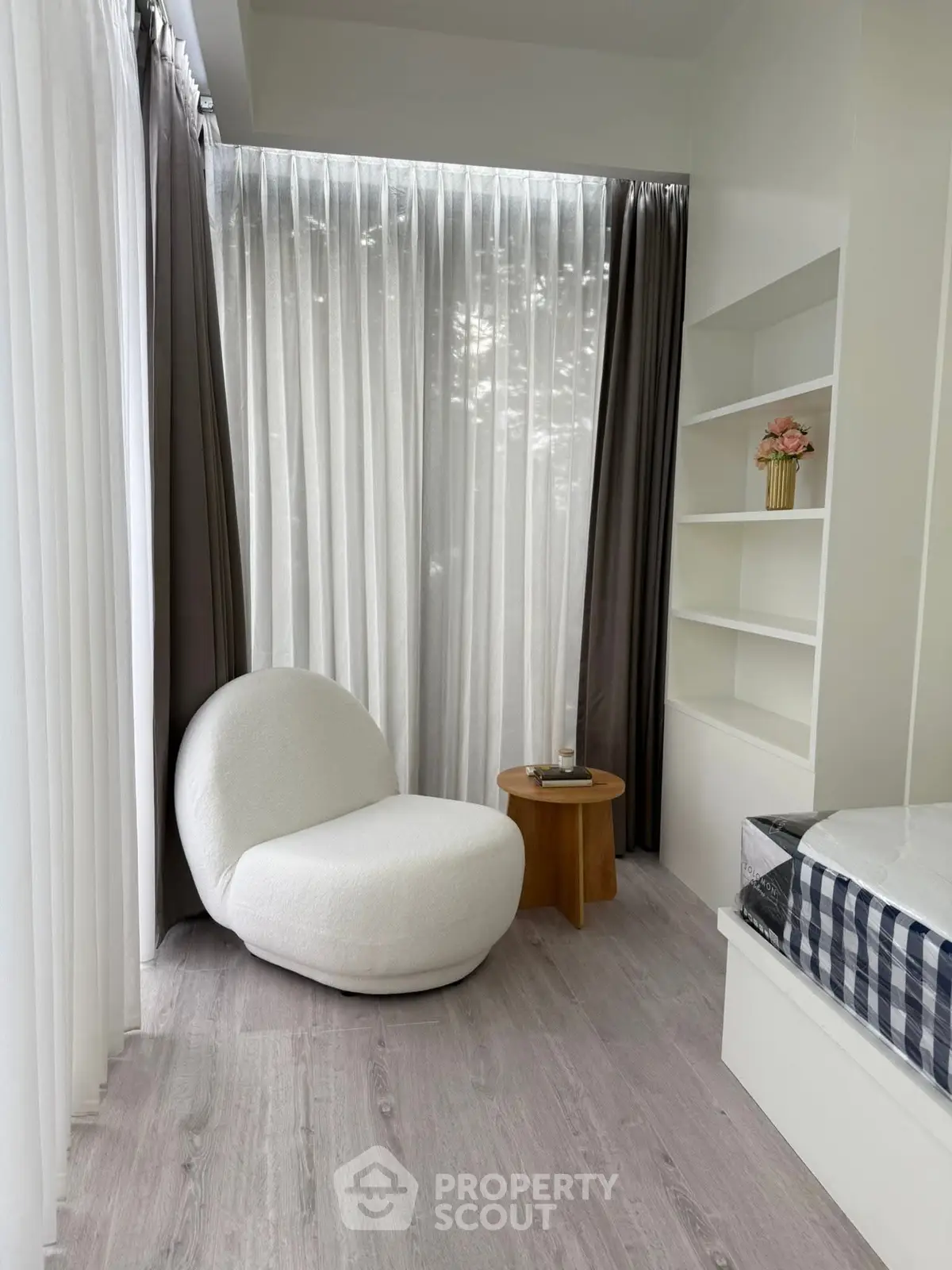 Cozy modern bedroom corner with plush chair and natural light