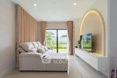 Modern living room with elegant sofa and large window overlooking garden
