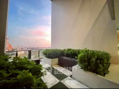 Stunning balcony with lush greenery and breathtaking city view at sunset.