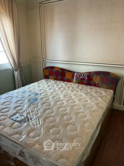 Spacious bedroom with elegant decor and new mattress in a cozy setting.