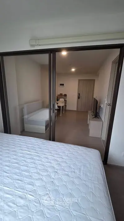 Modern apartment interior with sliding glass doors and minimalist furniture design.