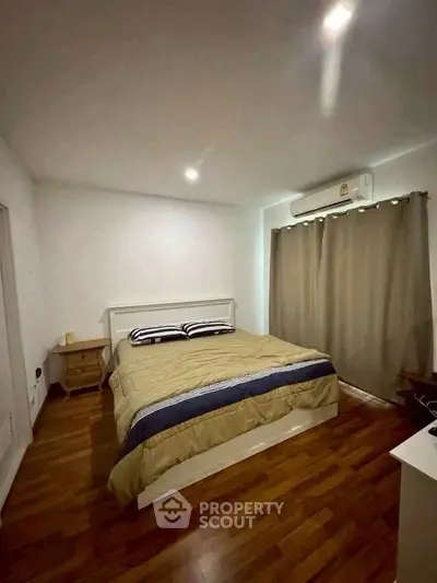 Cozy bedroom with wooden flooring and modern decor