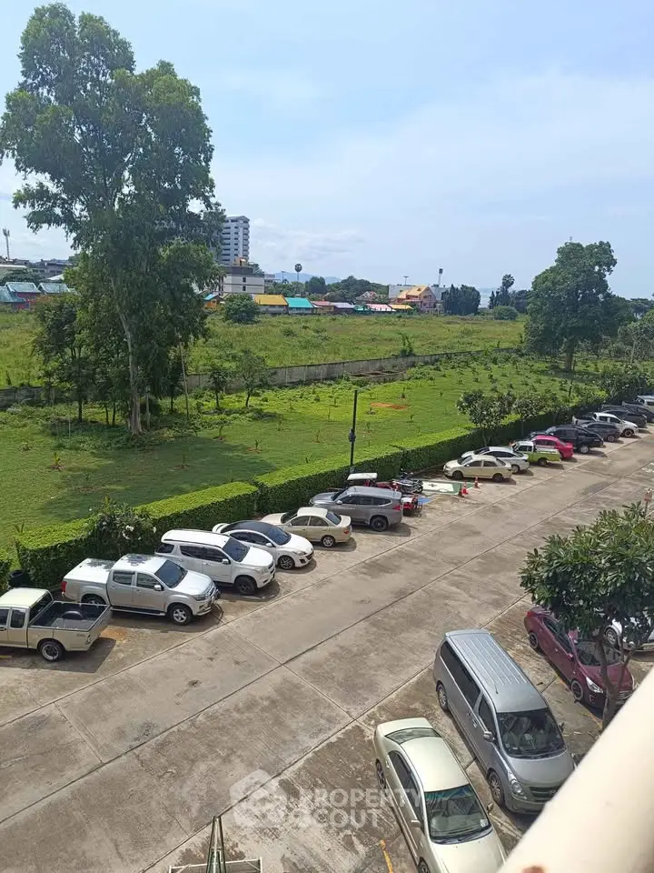 Scenic view of a parking lot with lush greenery and distant cityscape, ideal for urban living.