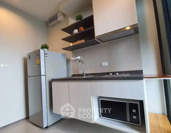 Modern compact kitchen with sleek cabinetry and stainless steel appliances.