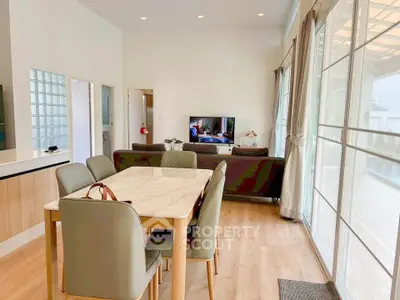Spacious living and dining area with modern decor and large windows for natural light.