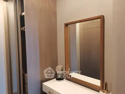 Modern bedroom with stylish wooden mirror and sleek storage solutions.