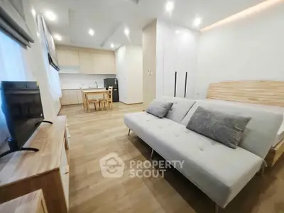 Modern open-plan living room with sleek kitchen and cozy sofa, perfect for urban living.