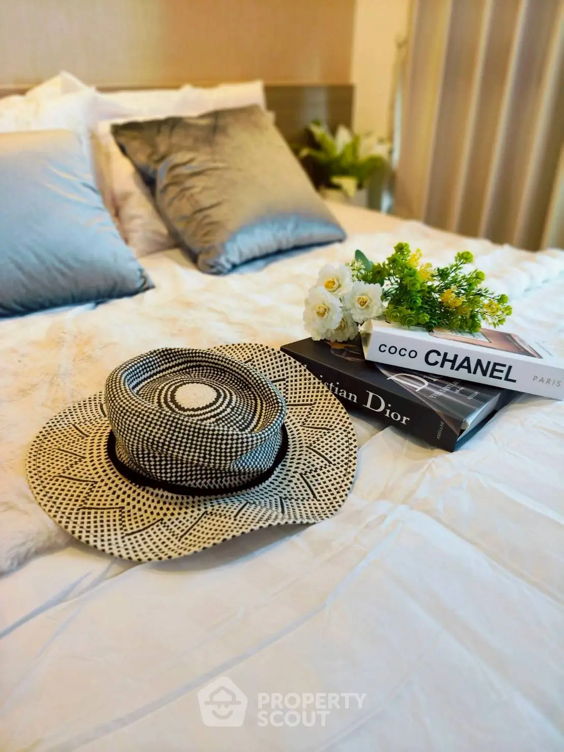 Luxurious bedroom with designer books and elegant decor, showcasing a sophisticated lifestyle.